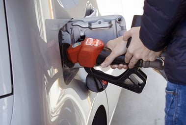 Close up of fuel being pumped into gas tank with person holding nozzle