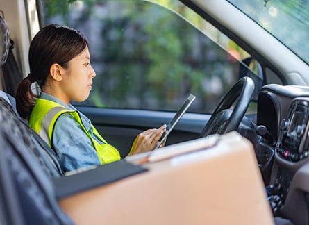 service worker woman at steering wheel in yellow vest using table